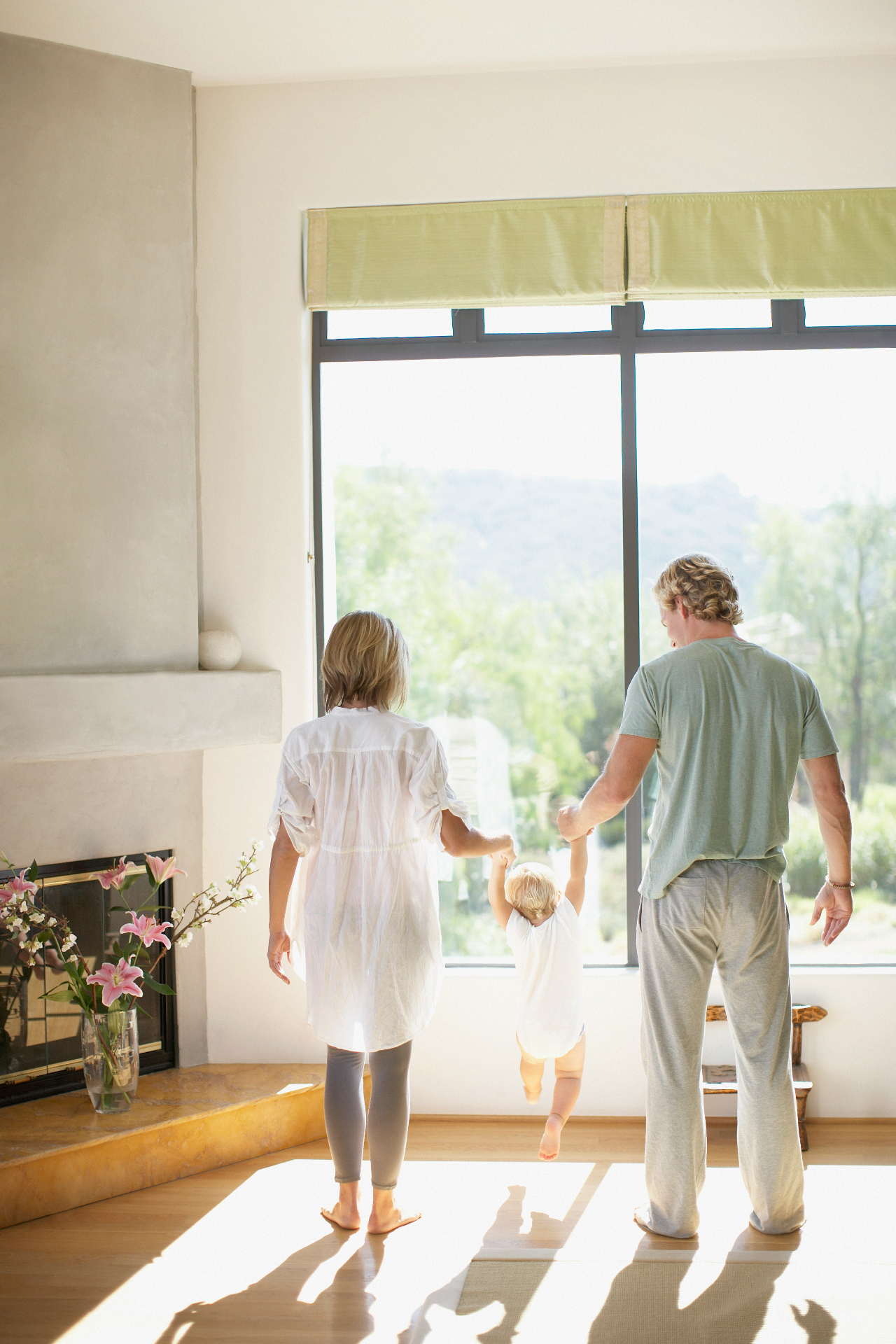 A joyful family playing together on a green lawn in front of a welcoming home